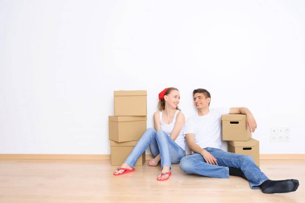 A couples smiling with boxes in Hurst, TX