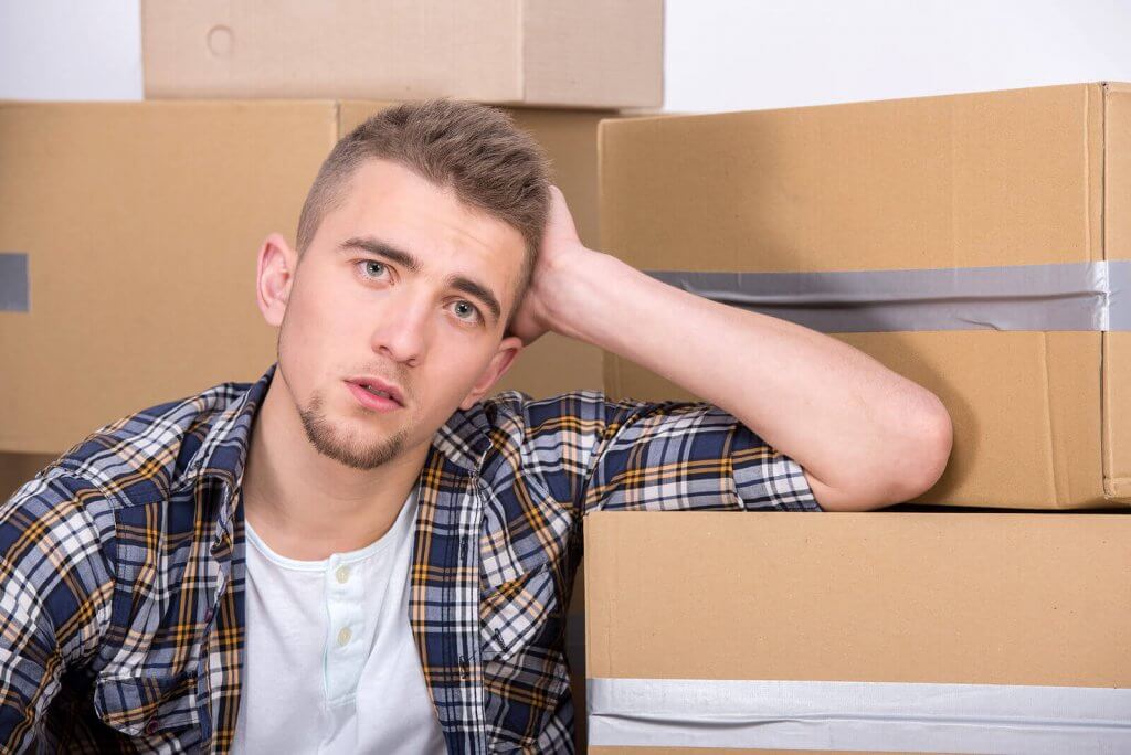 A man being stressed in the lot of boxes