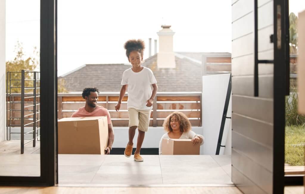 Shot of a family carrying boxes into their new home