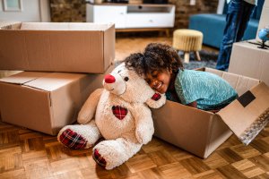 Young girl sleeping next to teddy bear in new home.