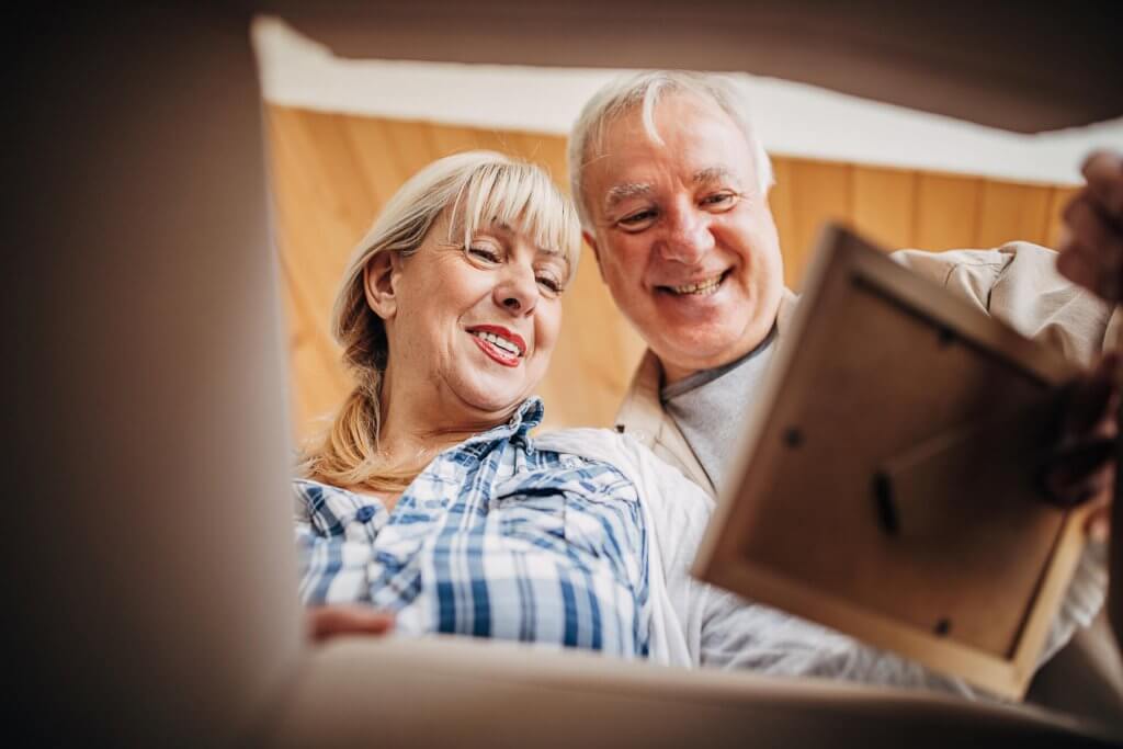Senior couple unpacking cardboard box together