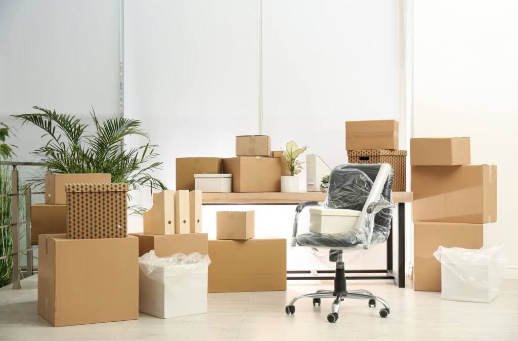 Cardboard boxes and packed chair in office. Moving day