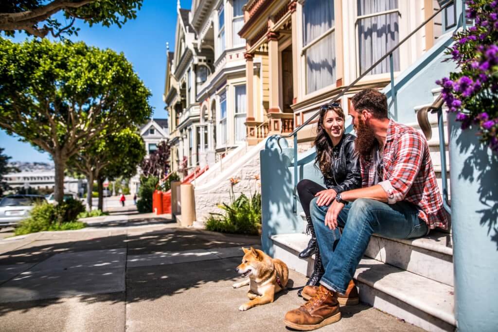 A couple with a dog on a city walk