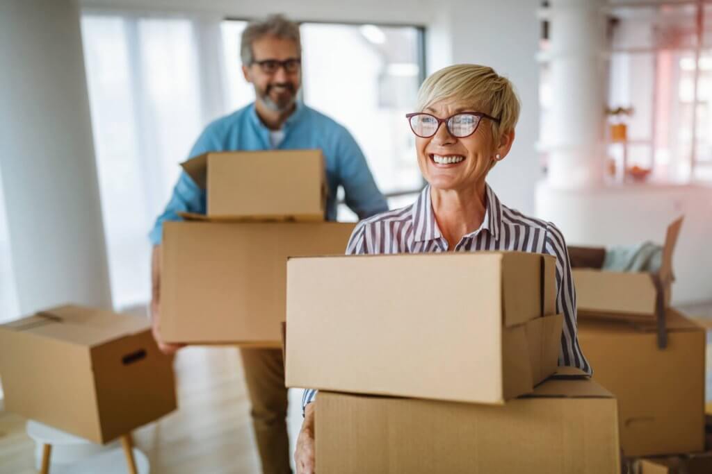 Portrait of happy senior couple moving in new home