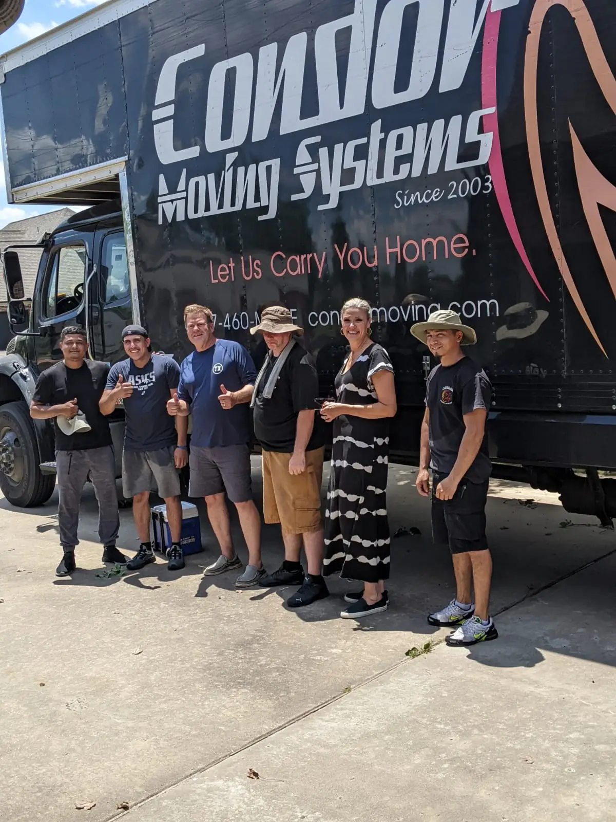 Condor Moving Systems crew standing with a customer in front of a Condor moving truck